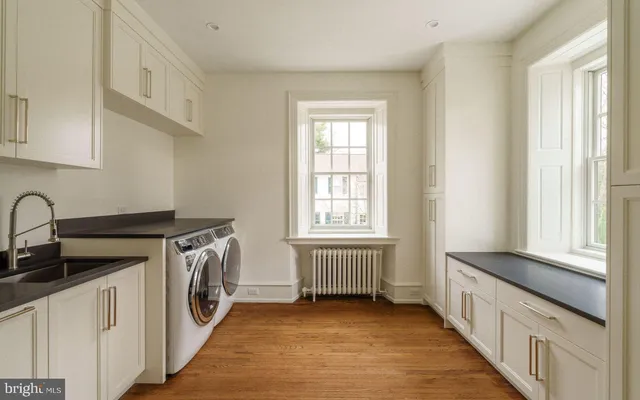 a bathroom with a granite countertop sink a toilet and a window