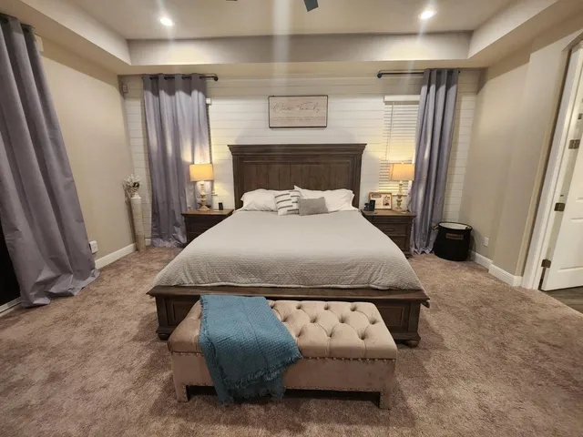 a bed sitting in a bedroom next to a window