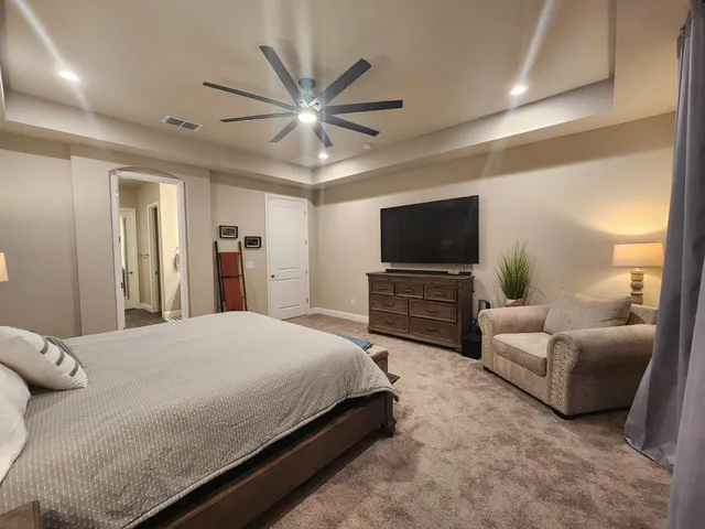 a bedroom with a bed and a flat screen tv