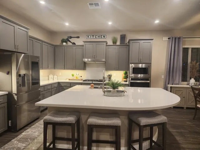 a kitchen with refrigerator a sink and chairs