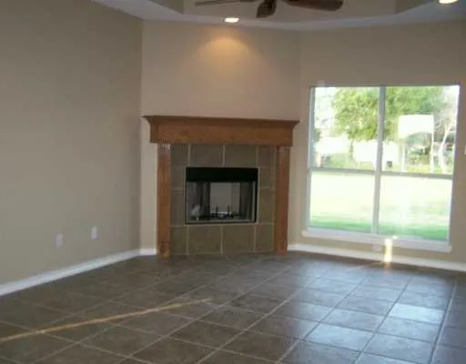 a view of an empty room with a fireplace and a window
