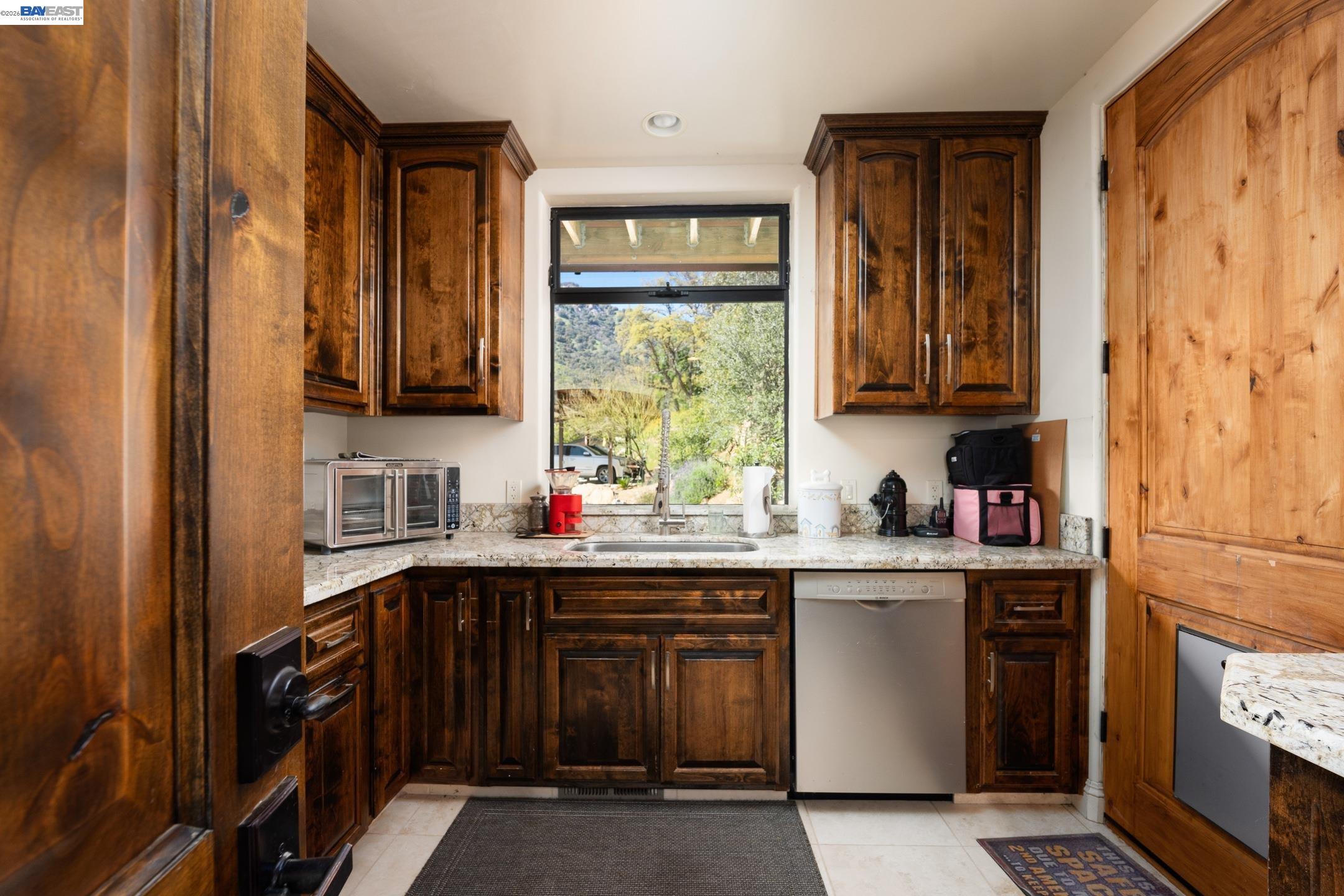48250 South Fork Drive Three Rivers, CA 93271 - Photo 23 of 48 a kitchen with granite countertop a stove a sink dishwasher and cabinets with wooden floor