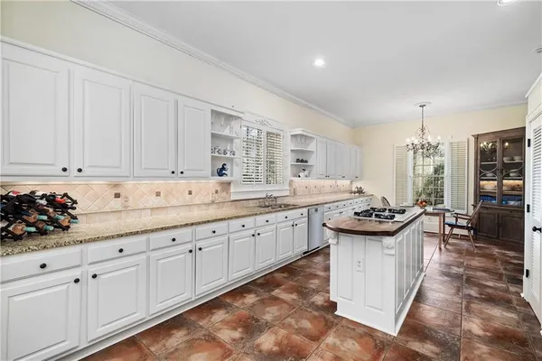 a kitchen with granite countertop a sink stove and cabinets
