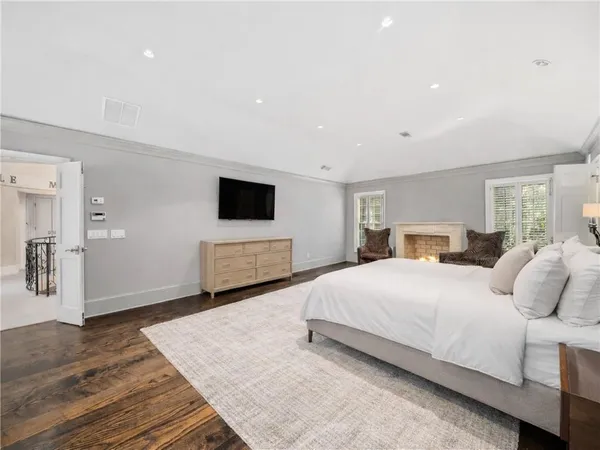 a bedroom with a large bed and a fireplace