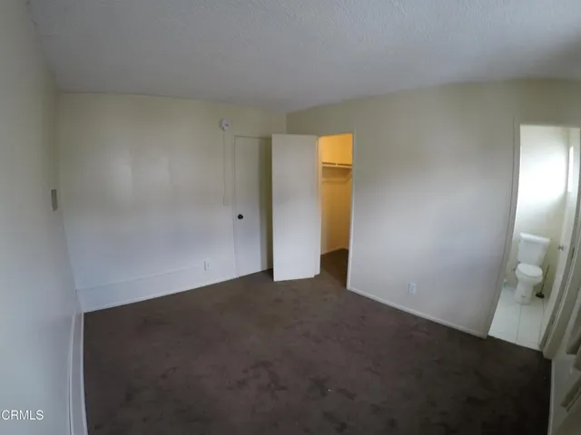 an empty room with closet and mirror