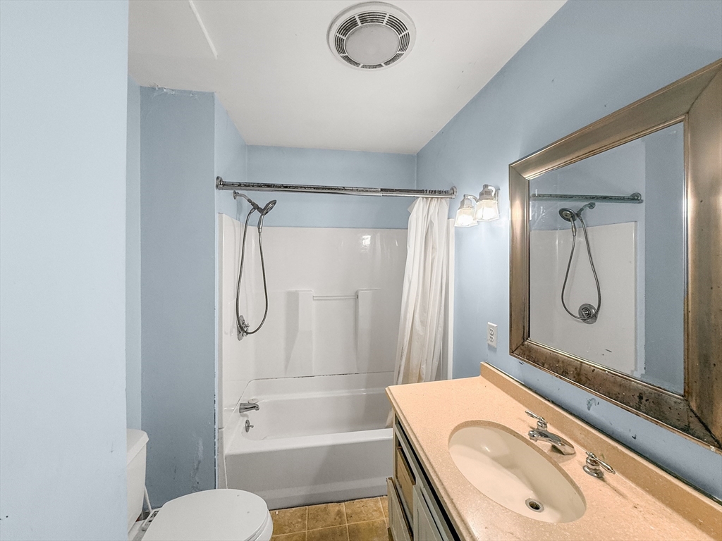265 Ames Street Lawrence, MA 01841 - Photo 7 of 18 a bathroom with a granite countertop sink mirror vanity and toilet