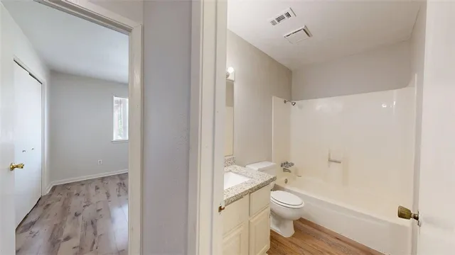 a bathroom with a granite countertop toilet a sink and a mirror