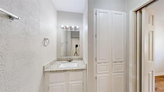 a bathroom with a granite countertop sink and a mirror