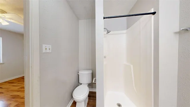 a white toilet sitting next to a shower curtain