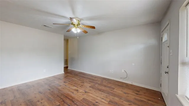 a view of a room with wooden floor and ceiling fan