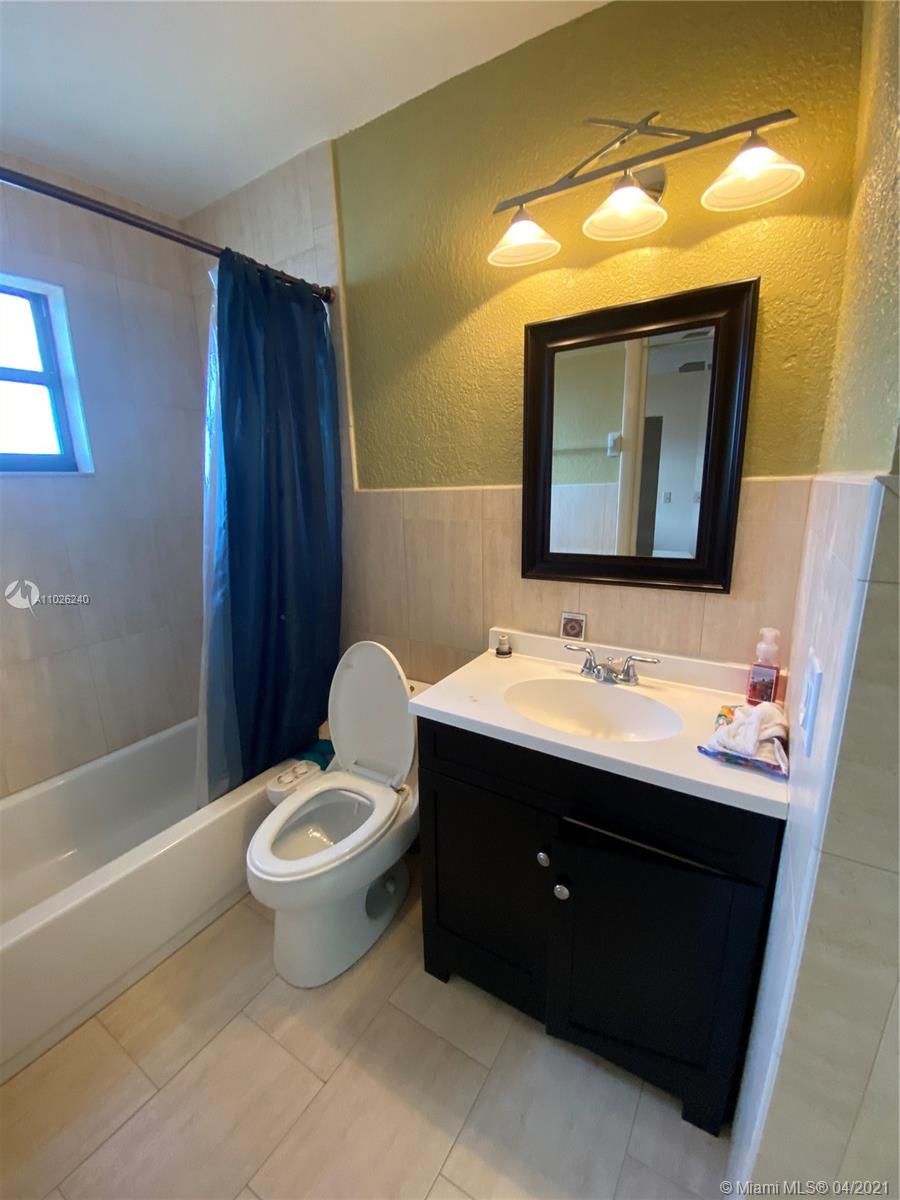 5900 West 18th Avenue, Unit A14 Hialeah, FL 33012 - Photo 3 of 29 a bathroom with a toilet sink and mirror