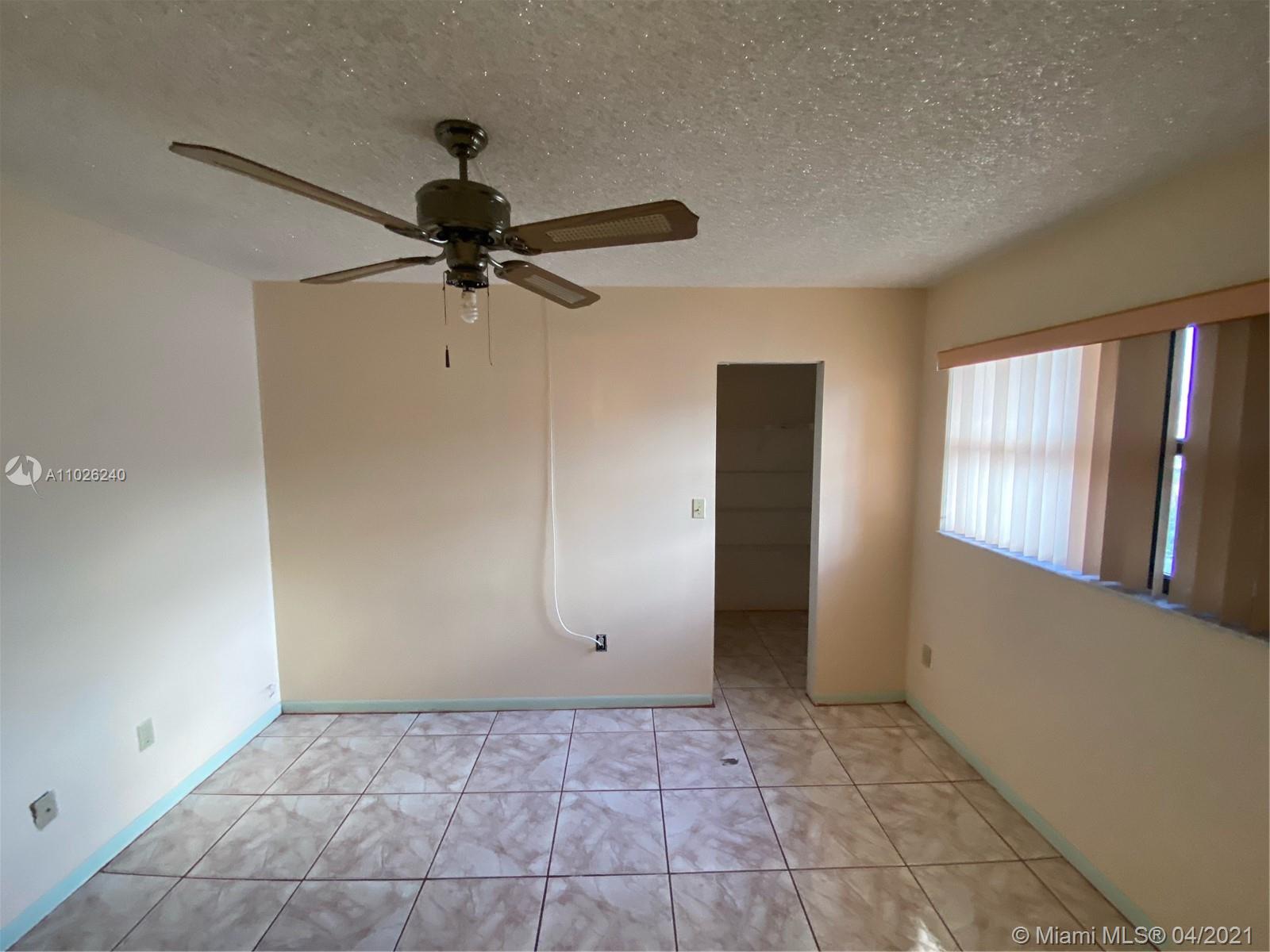 5900 West 18th Avenue, Unit A14 Hialeah, FL 33012 - Photo 25 of 29 a view of a livingroom with a ceiling fan and window