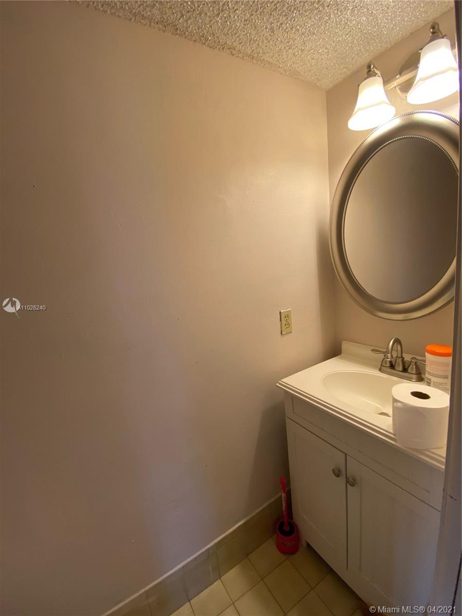 5900 West 18th Avenue, Unit A14 Hialeah, FL 33012 - Photo 26 of 29 a bathroom with a sink and a mirror