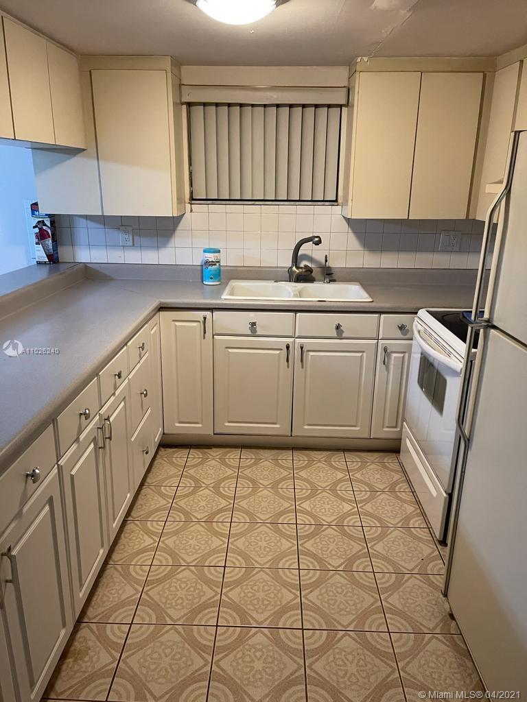 5900 West 18th Avenue, Unit A14 Hialeah, FL 33012 - Photo 7 of 29 a kitchen with a sink a stove and cabinets