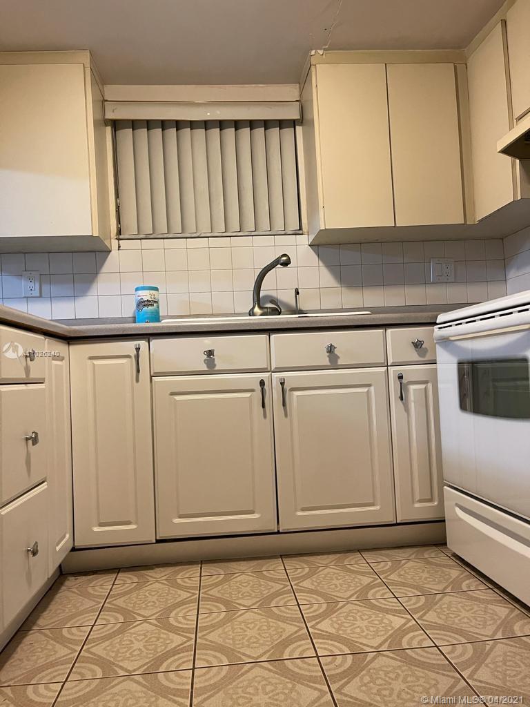 5900 West 18th Avenue, Unit A14 Hialeah, FL 33012 - Photo 10 of 29 a kitchen with white cabinets