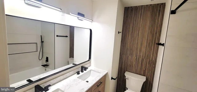 a bathroom with a tub a sink and a large mirror