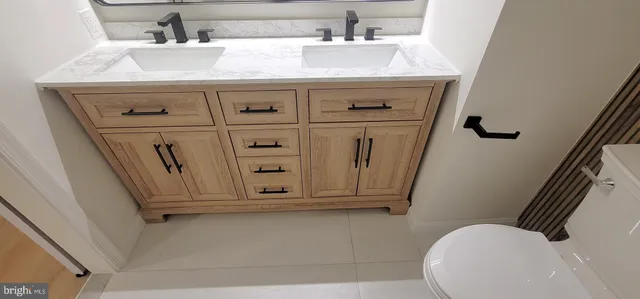 a bathroom with a sink a toilet and mirror