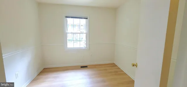 a view of a small space with wooden floor and a window