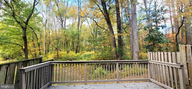 a balcony with wooden floor and trees
