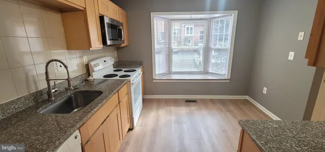 a kitchen with a sink a stove and cabinets