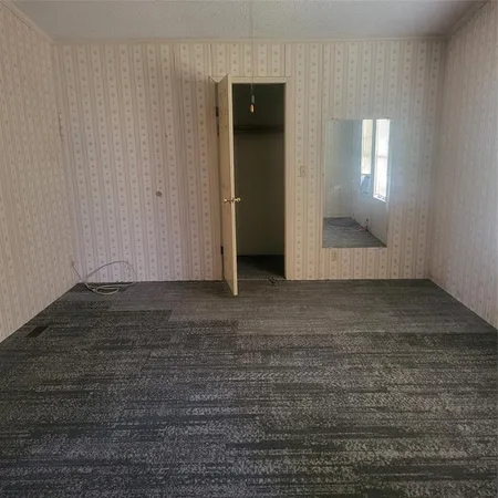 an empty room with wooden floor and mirror