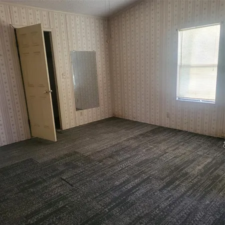 an empty room with wooden floor and a window