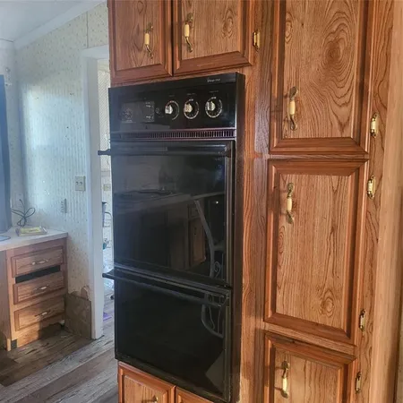 a kitchen with granite countertop white cabinets and stainless steel appliances