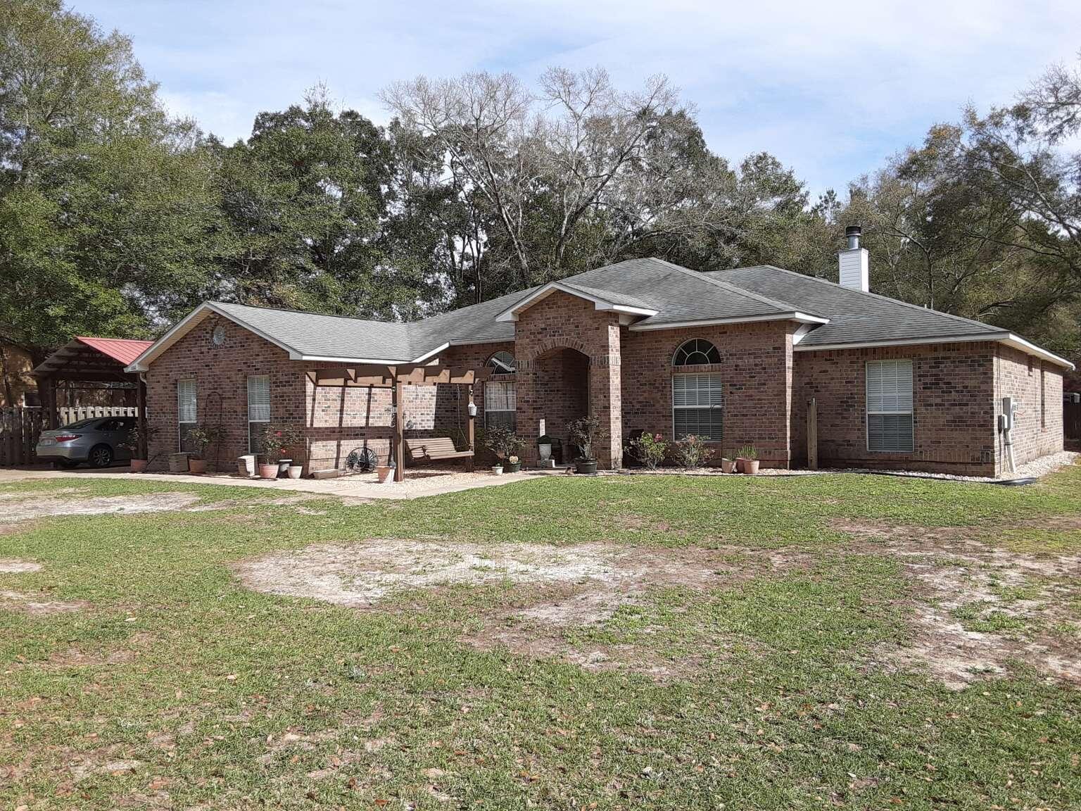 100 Cedar Place Freeport, FL 32439 - Photo 1 of 9 a front view of a house with garden