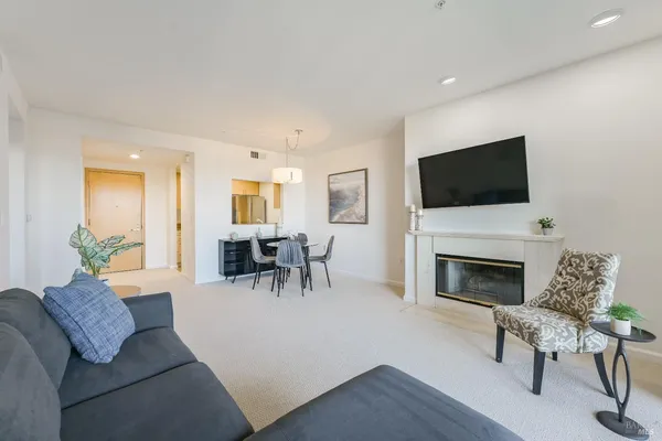 a living room with furniture a fireplace and a flat screen tv