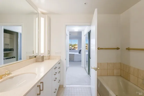 a spacious bathroom with a bathtub sink and mirror