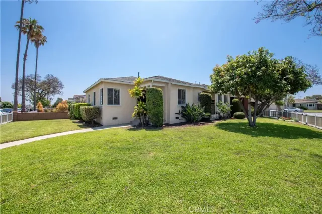 a front view of a house with a garden and plants