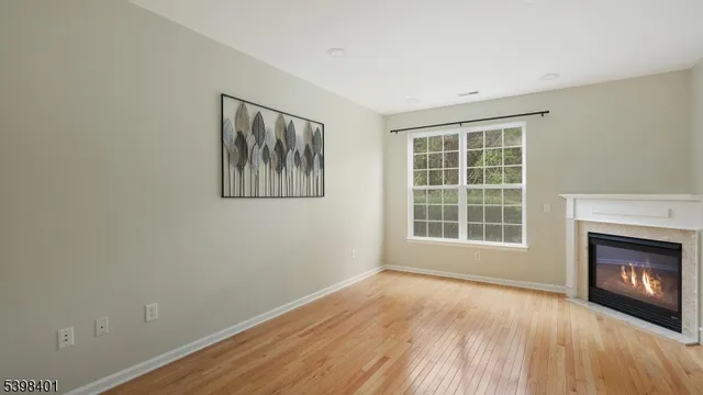 a view of an empty room with a window and a fireplace