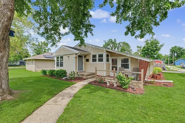 a front view of house with a garden and yard