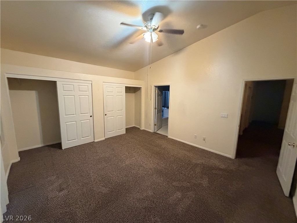7629 Rory Court Las Vegas, NV 89129 - Photo 8 of 25 A well-lit room featuring vaulted ceilings and comfortable carpet flooring, ready for personalization.