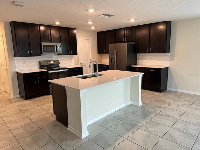 a kitchen with stainless steel appliances a refrigerator sink and microwave