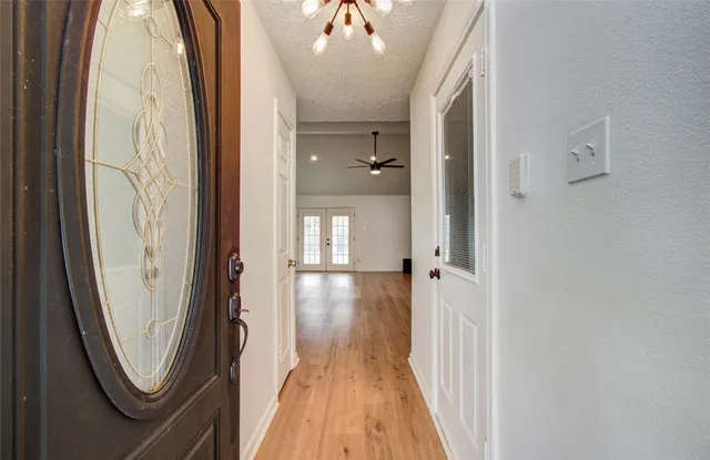 a view of a hallway with wooden floor and staircase