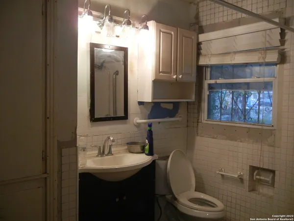 a bathroom with a toilet a sink and mirror