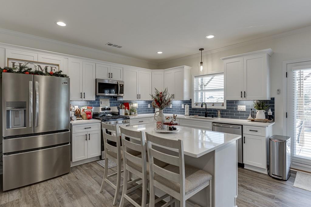 236 Ralph Still Road Dacula, GA 30019 - Photo 45 of 68 a kitchen with stainless steel appliances a refrigerator a stove a sink a table and chairs