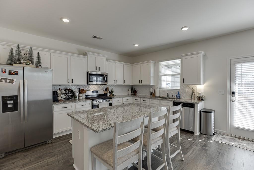 236 Ralph Still Road Dacula, GA 30019 - Photo 9 of 68 a kitchen with stainless steel appliances granite countertop a stove a sink a microwave a refrigerator and white cabinets