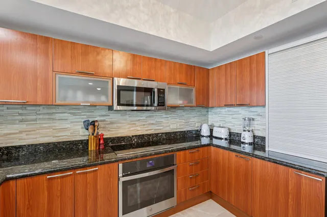 a kitchen with stainless steel appliances granite countertop a refrigerator and a stove