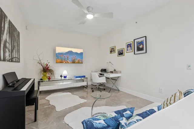 a living room with furniture and a dining table with kitchen appliances