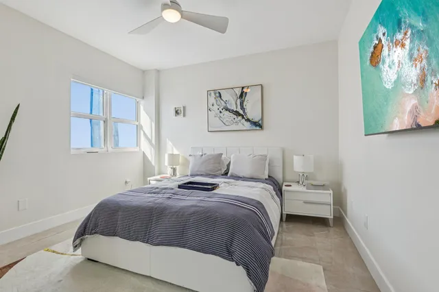 a bedroom with a large bed and a potted plant