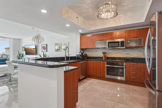 a kitchen with stainless steel appliances granite countertop a sink a stove cabinets and a counter top space