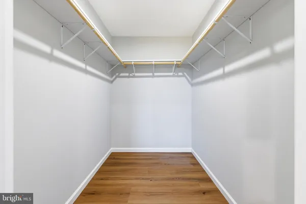 an empty room with wooden floor and a ceiling fan