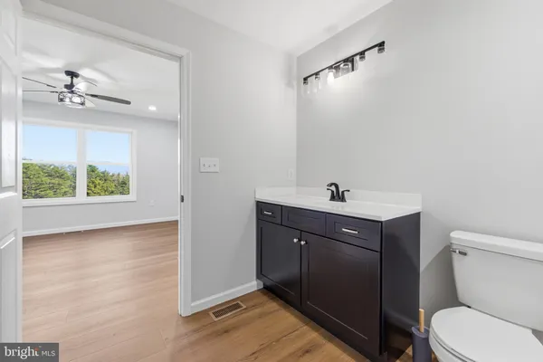 a view of an empty room with wooden floor and cabinets
