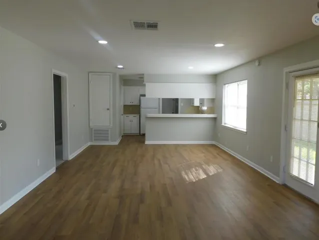 a view of empty room with wooden floor and window