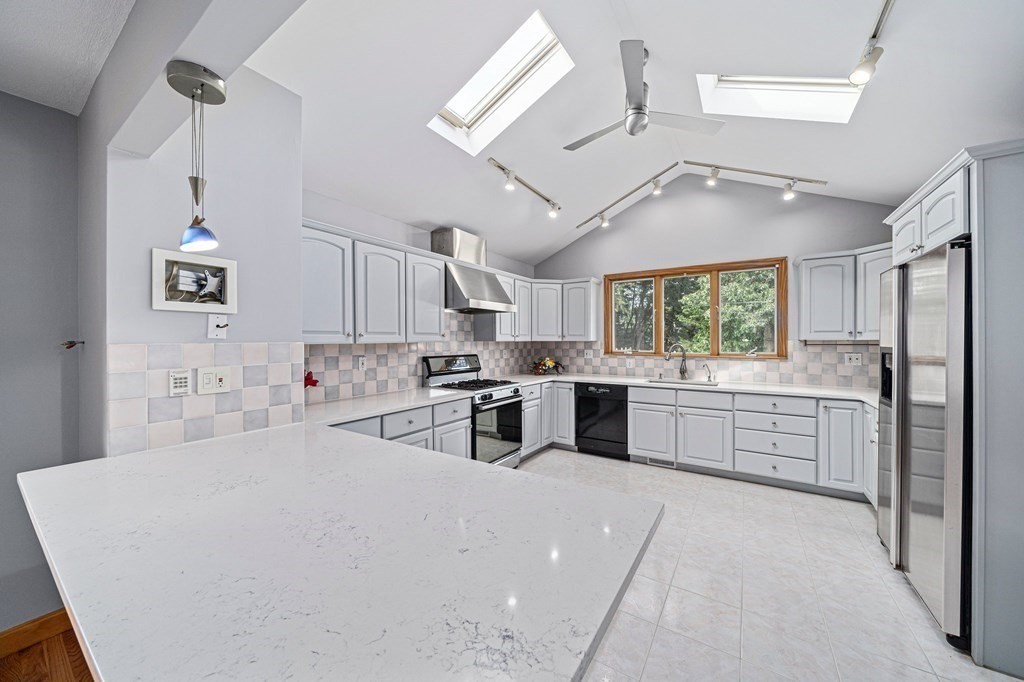 19 Ledge Hill Street Randolph, MA 02368 - Photo 10 of 37 a kitchen with stainless steel appliances a refrigerator a sink dishwasher a oven with white cabinets and wooden floor