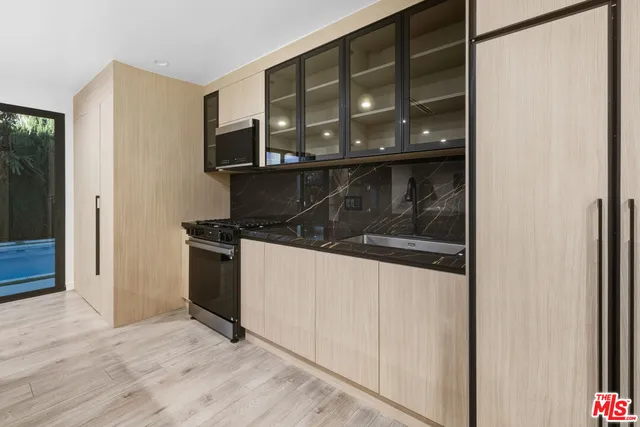 a kitchen with stainless steel appliances granite countertop a refrigerator and a stove