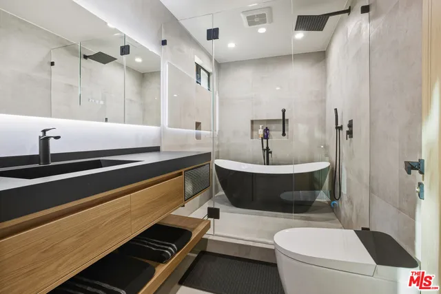 a bathroom with a sink a toilet and a mirror