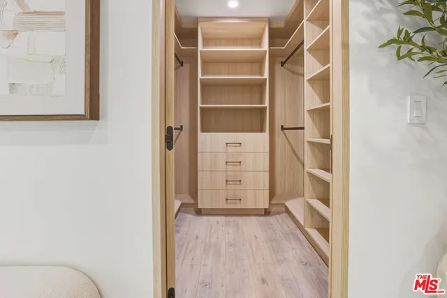 a view of walk in closet with empty racks